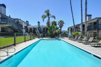 Poolside sundeck with lounge seating and picnic tables